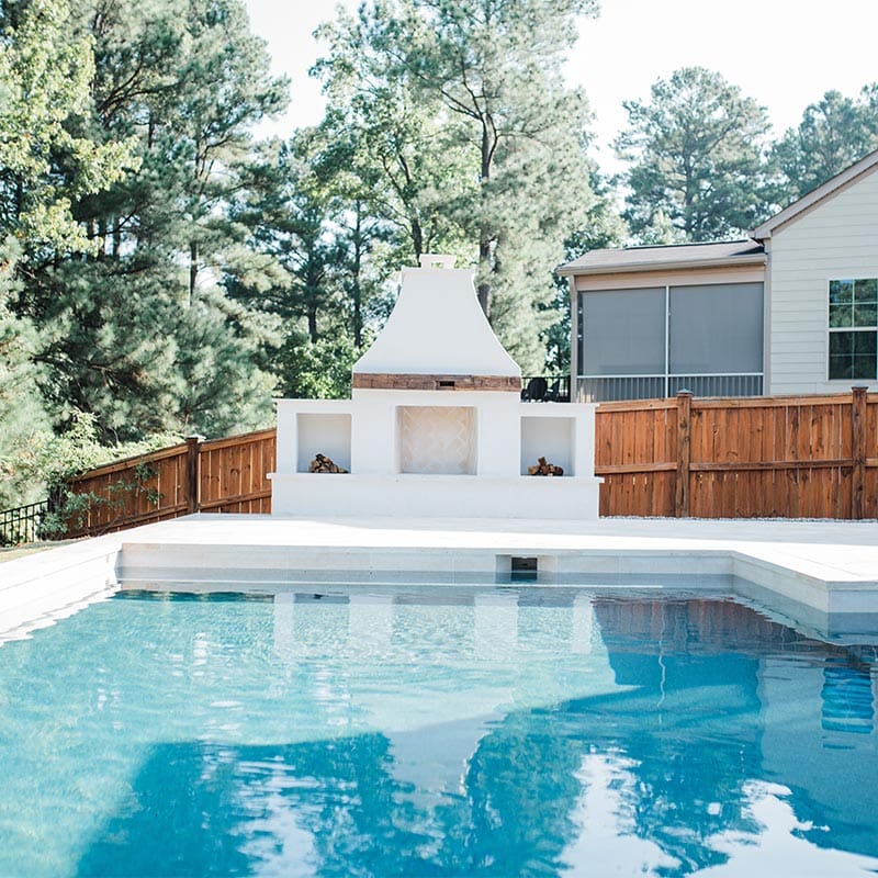 Front view of pool with white fireplace