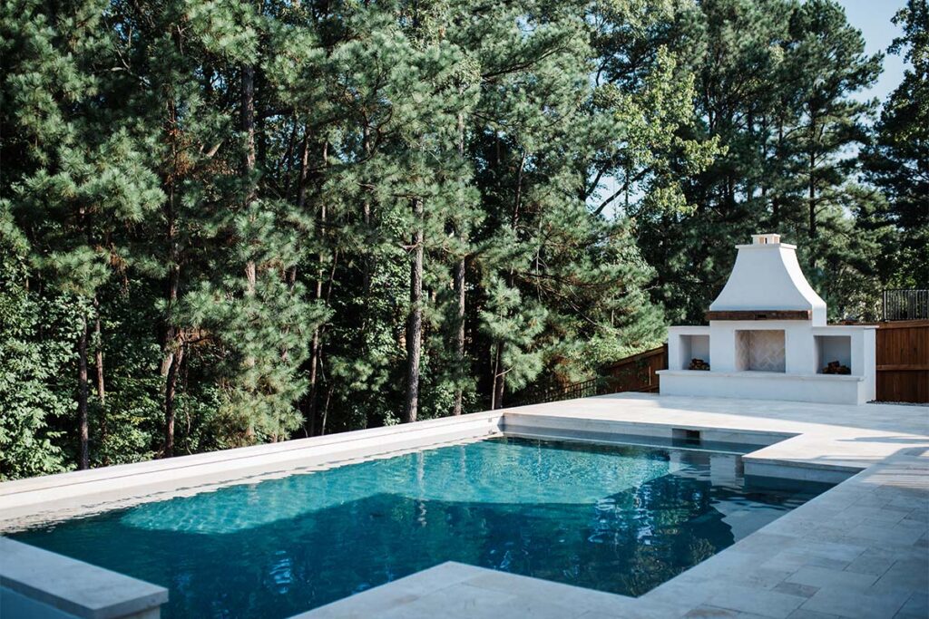 Contemporary Durham corner view showing concrete pool and white fireplace