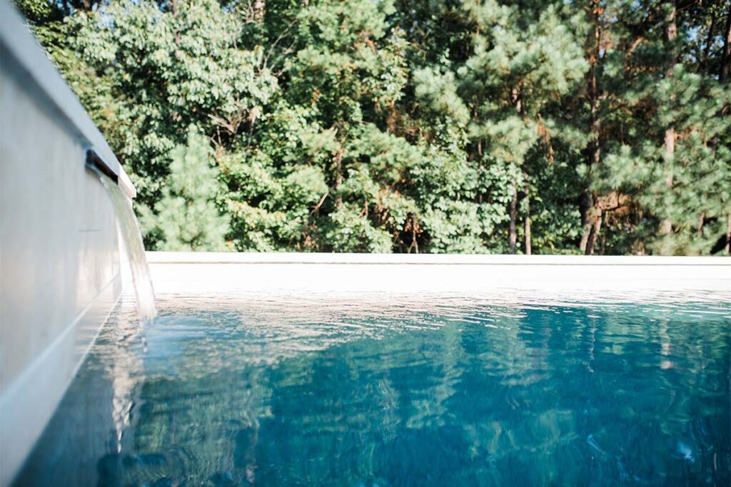 Side view of Contemporary Durham pool showing on the left wall with water pouring into the concrete pool