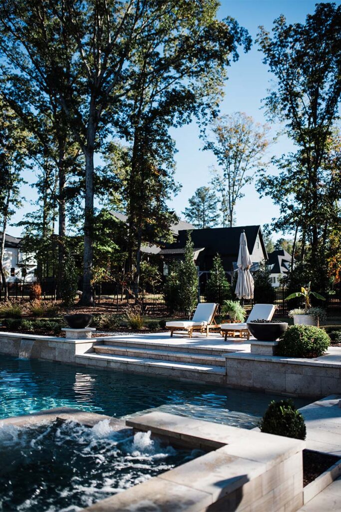 Concrete pool in Raleigh featuring spill over spa in the foreground