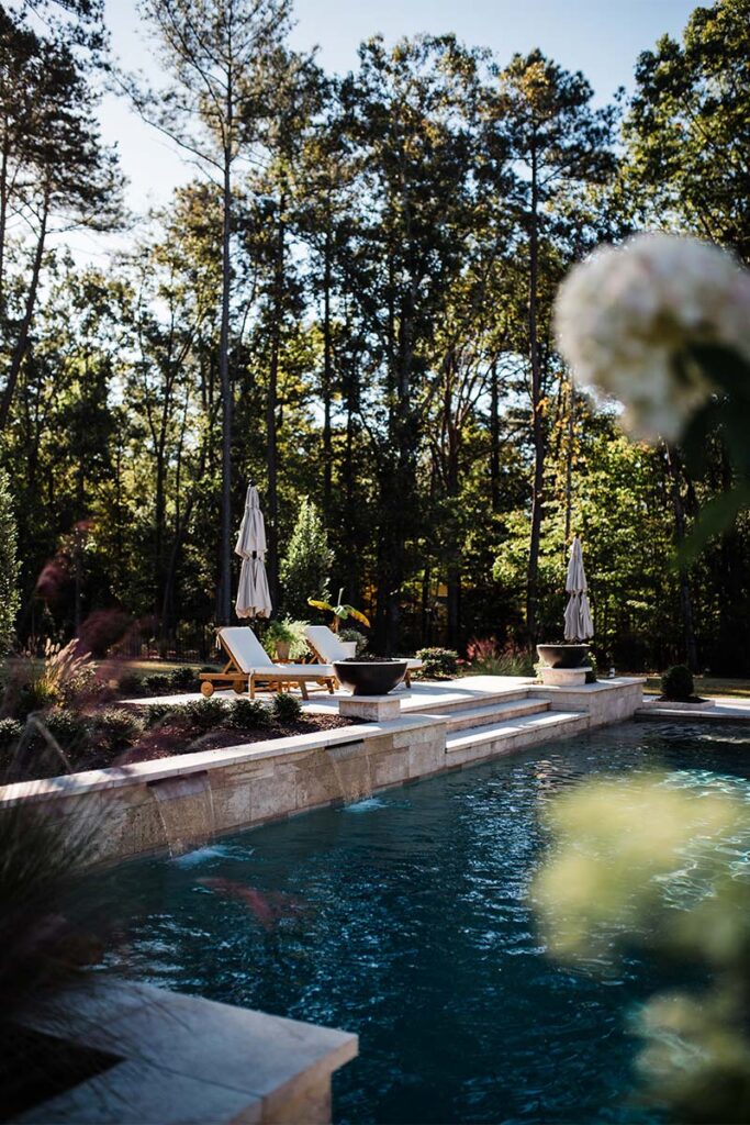 Contemporary Raleigh concrete pool in the background and flowers in the foreground out of focus