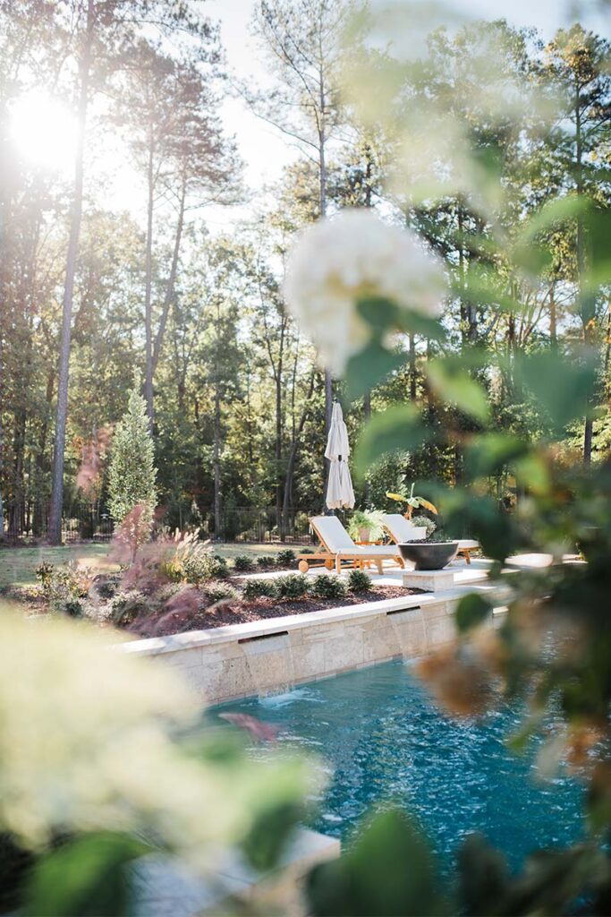 Contemporary Raleigh concrete pool with out of focus flowers in the foreground
