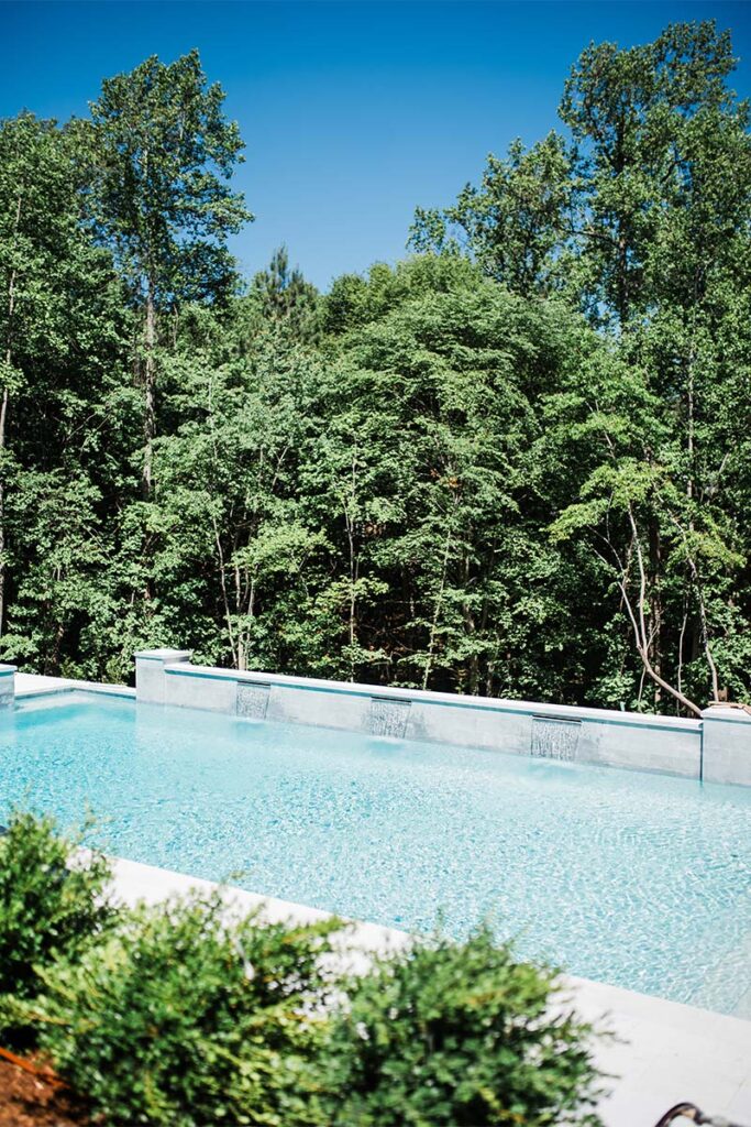 Zoomed out view of Formal Cary pool, showcasing White Diamond PebbleTec Plaster