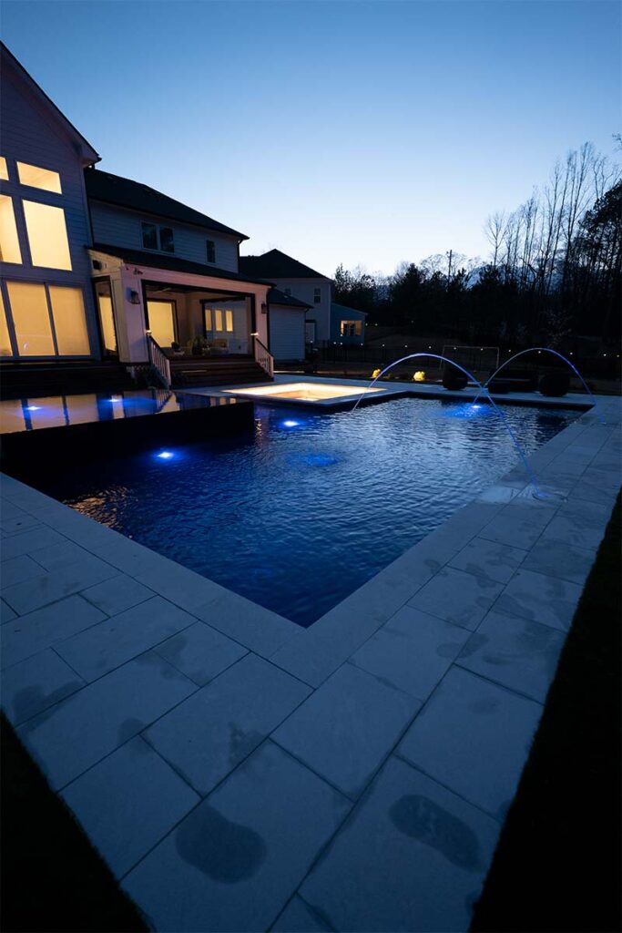 Concrete Pool at night, Modern Apex showcase pool lighting and spill over spa