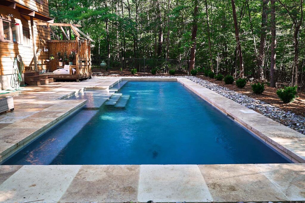 Side view of custom Concrete pool in Chapel Hill, NC. Rustic Chapel Hill features custom concrete pool design walkways