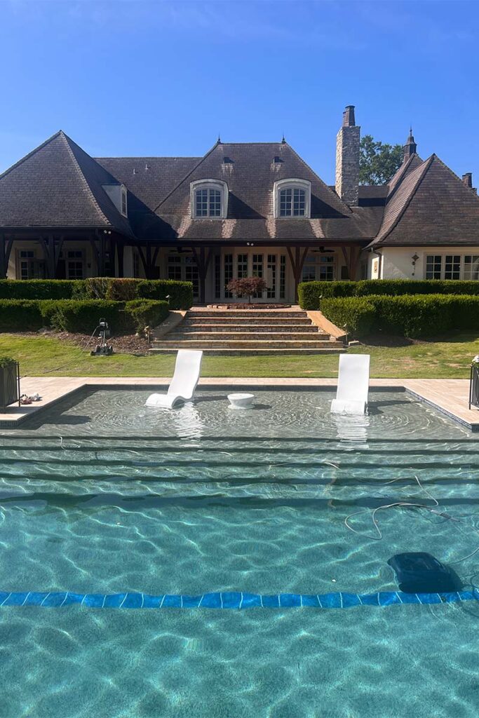 Front view of Classic Costal concrete pool with home in the background
